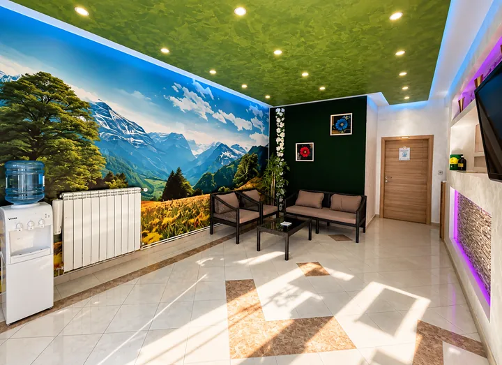 Prostorija sa zidnim pejzažom planina i foteljama